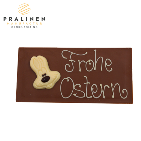 Vollmilch-Schokoladentafel mit einem Osterhasenkopf aus weißer Schokolade und dem Schriftzug Frohe Ostern